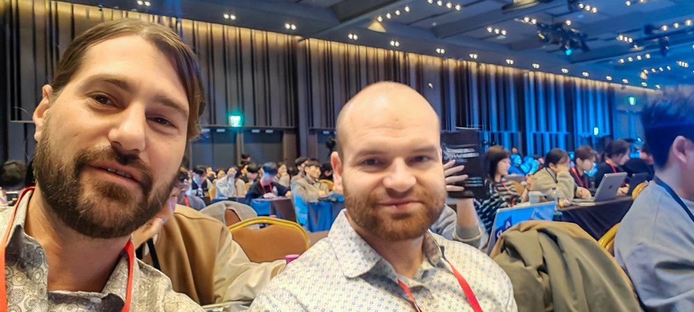 Zwei Kollegen von Vishnu Artists im Konferenzsaal des AI Summit.
