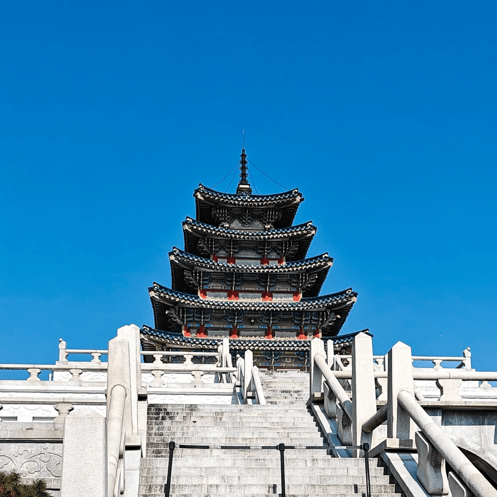 Fünfstöckige Pagode des Nationalen Volkskundemuseums in Seoul vor blauem Himmel.