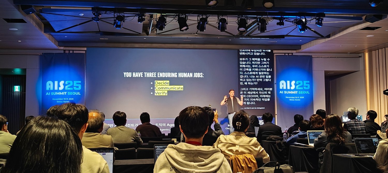 Publikum des AI Summit Seoul vor einer Folie mit den Worten Decide, Communicate, Verify.